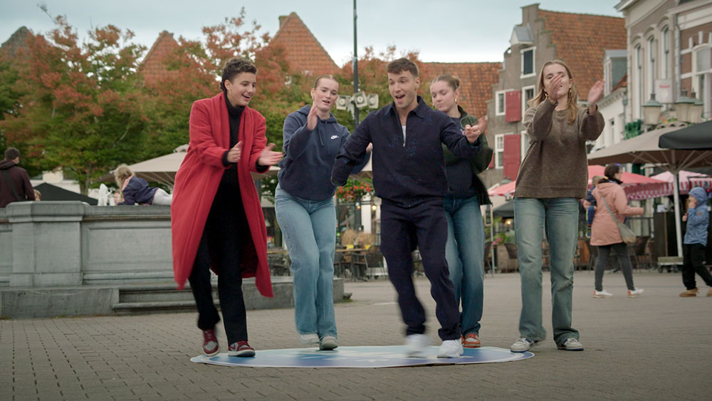 Vier dansende mensen op een plein